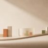 Abstract, minimalist illustration suggesting a grocery-store analogy: a softly curved shelf-like line, a few small muted-color blocks, and a translucent container shape arranged with ample negative space on a warm neutral background. Subtle gradients and diffused lighting create a calm, understated feel. No people, text, labels, or recognizable store items.